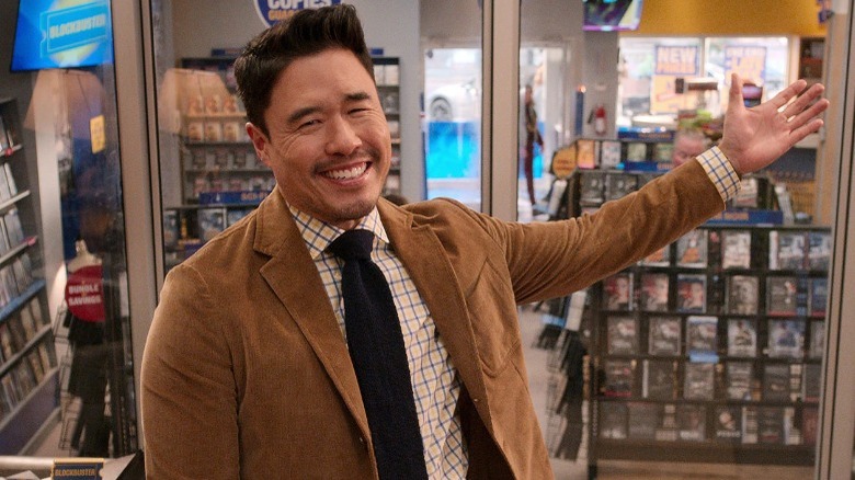 Randall Park smiling and pointing in Blockbuster