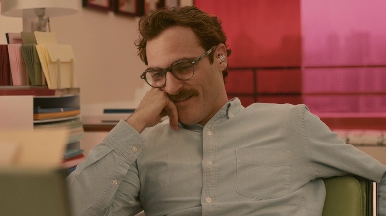 Theodore smiles at his desk in "Her" (2013)