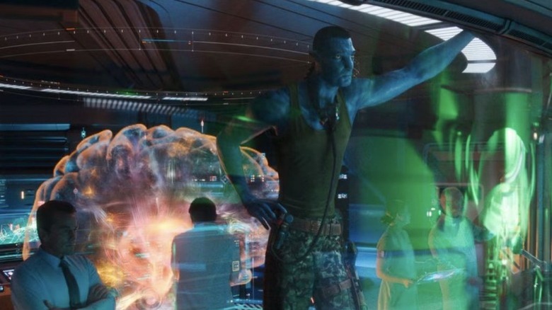 Quaritch in Na'vi avatar studying holograms