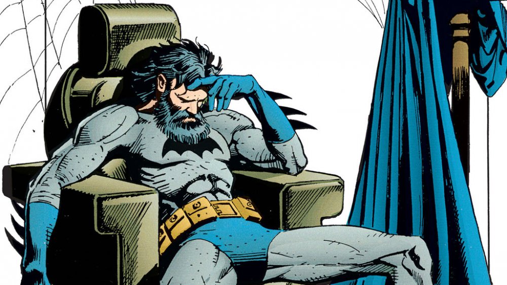 A weary, bearded Batman sinks into his chair on the cover of Batman: Legends of the Dark Knight #18, from DC Comics