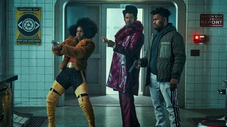 John Boyega, Jamie Foxx, Teyonah Parris holding guns