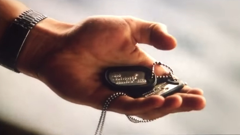 Maverick holds Goose's dog tags