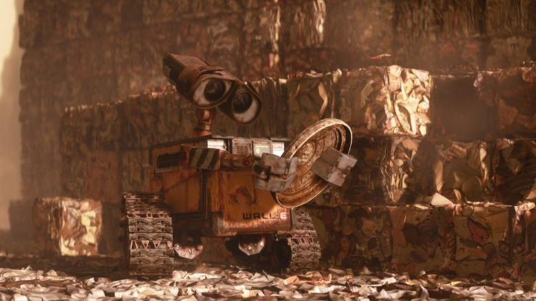 Wall-E inspects a piece of trash