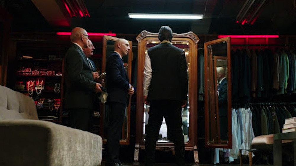 Keanu Reeves as John Wick trying on suits in John Wick: Chapter 2