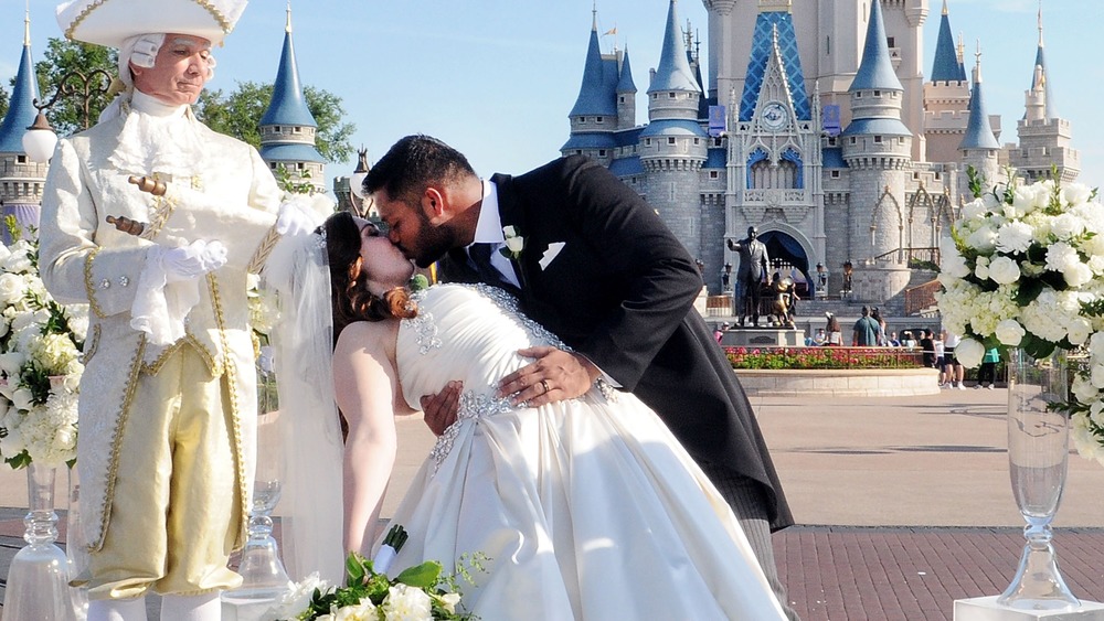 Alexis Preston and Jay Patel kiss at their wedding, in front of Walt Disney World's Cinderella Castle