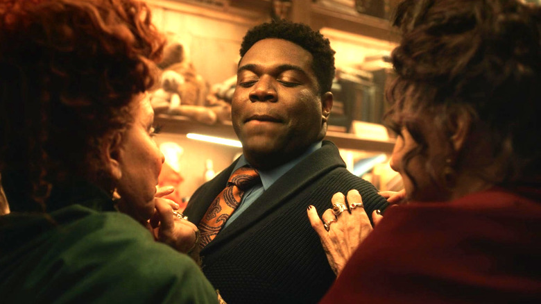 Sam Richardson looks down at the witches