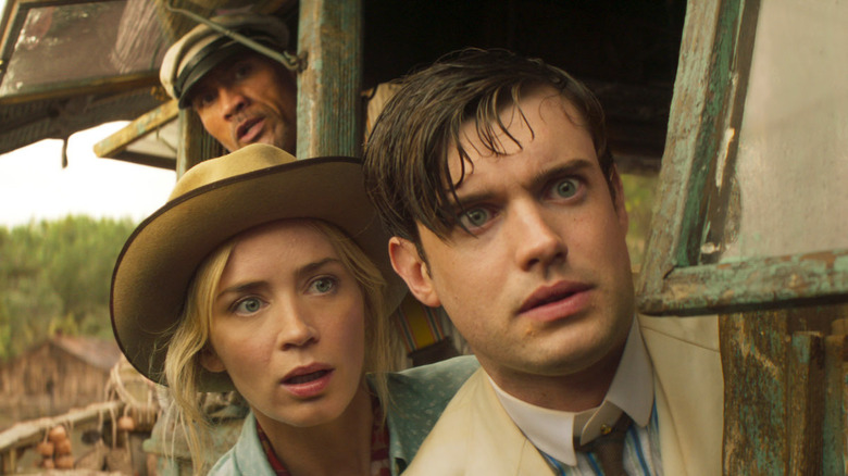 Johnson, Blunt, and Whitehall looking out of their boat in Jungle Cruise