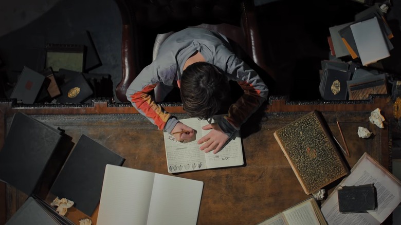 Boy sitting at desk looking up