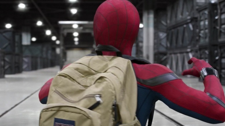 Spider-Man wears a backpack while exploring a warehouse