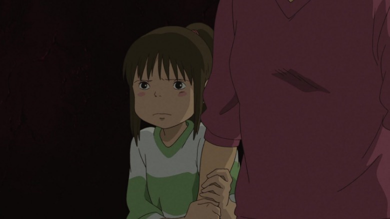 Chihiro clutching her mother's arm