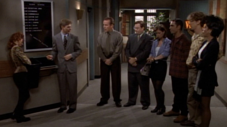 The cast of NewsRadio gathers in a hallway