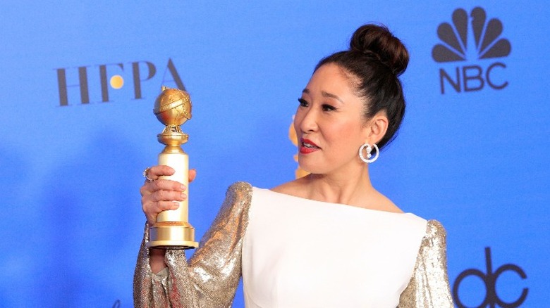 Sandra Oh holding a Golden Globe award