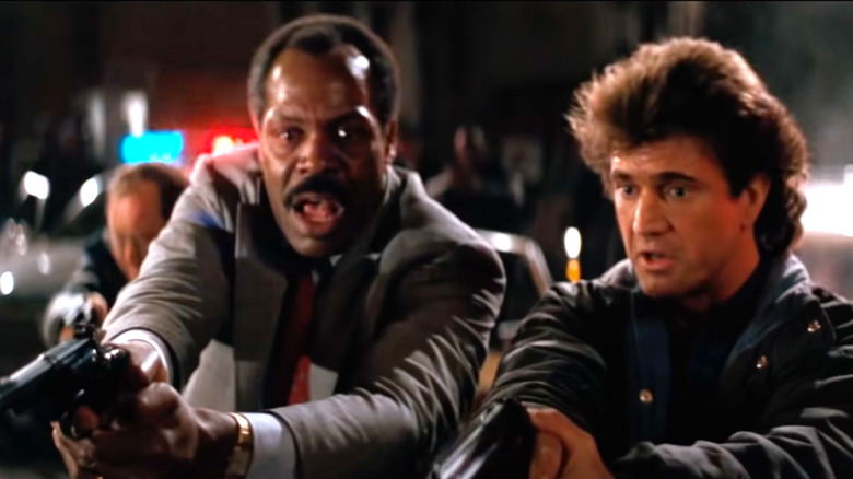 Riggs and Murtaugh point their guns