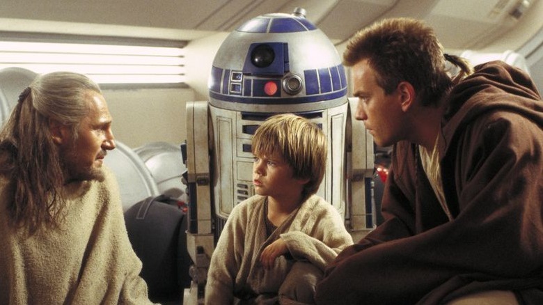 Qui-Gon Jinn, Anakin Skywalker, and Obi-Wan Kenobi speak while R2-D2 looks on