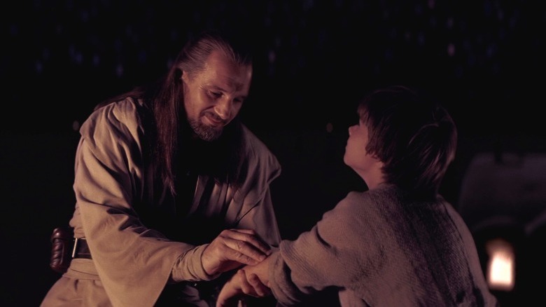 Qui-Gon Jinn administers a blood test to Anakin Skywalker's arm