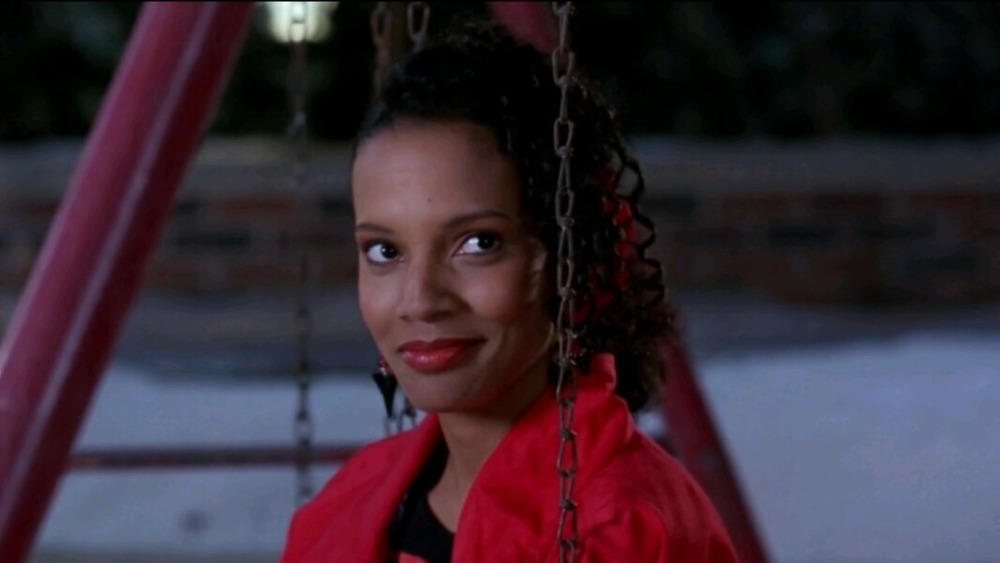 Lisa smiling on a swing in Coming to America