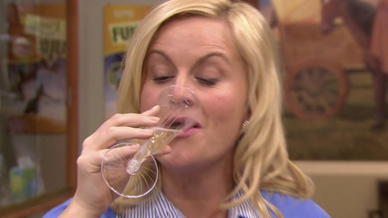 Leslie drinking champagne