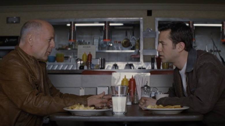 Bruce Willis and Joseph Gordon-Levitt sit across each other