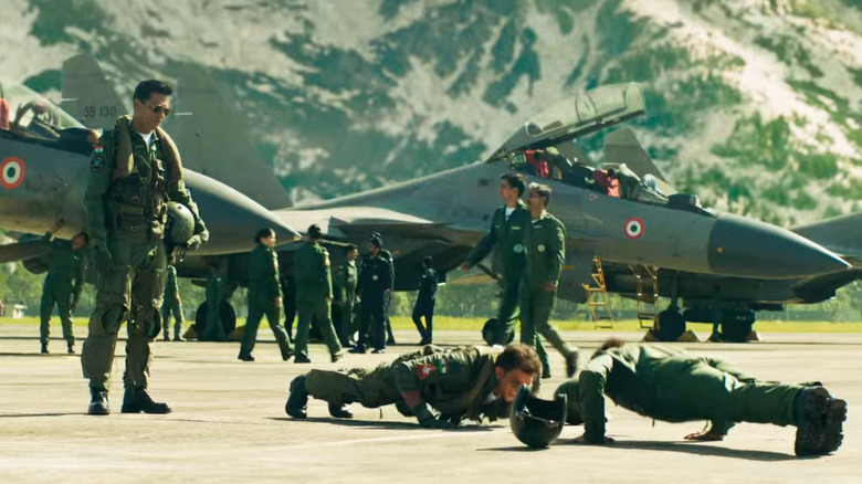 Pilots doing push-ups by planes