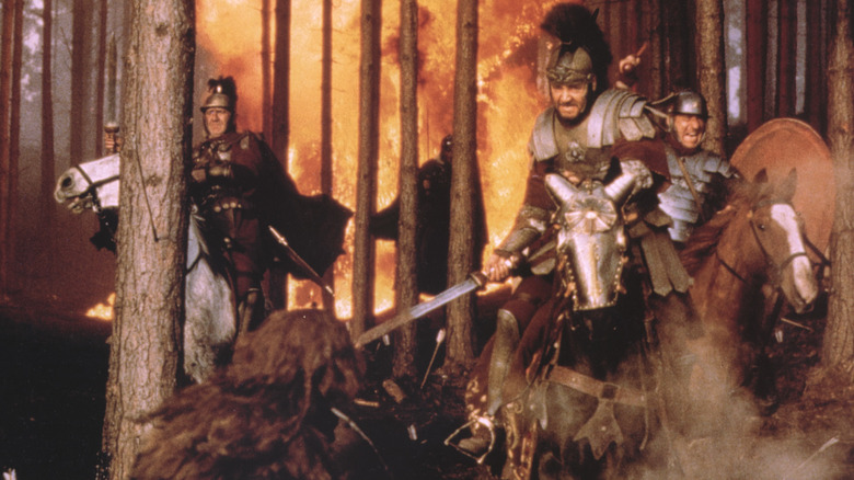 Russell Crowe riding a horse through a forest in flames 