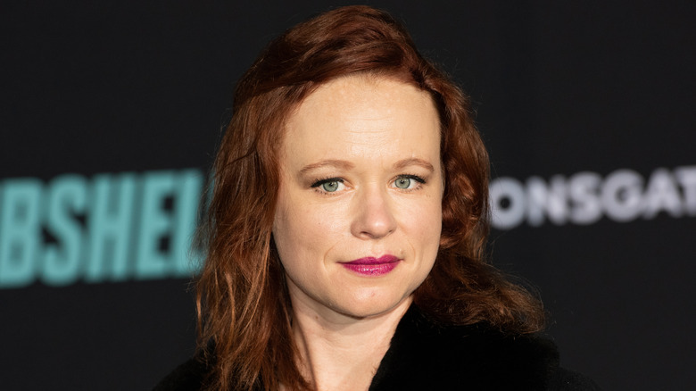 Thora Birch on Bombshell red carpet with Lionsgate logo on board behindher