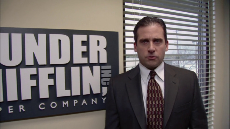 Michael Scott in front of sign