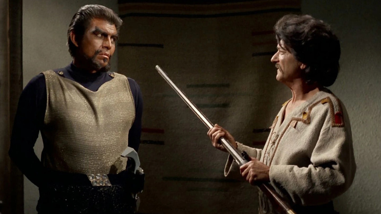 A Klingon offers up a rifle