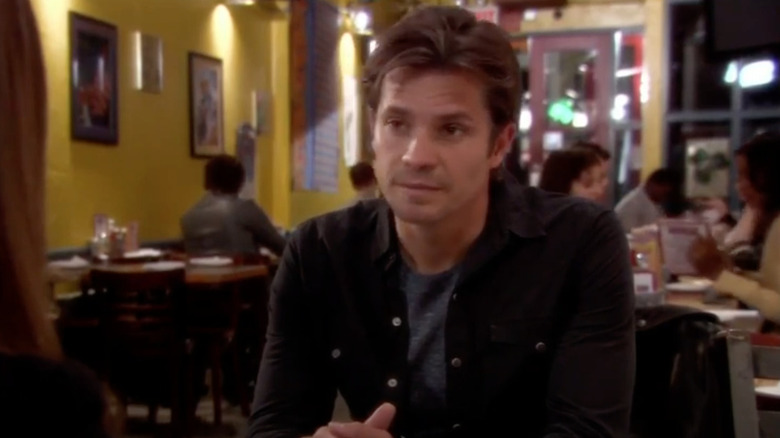 Timothy Olyphant sits at a table Damages