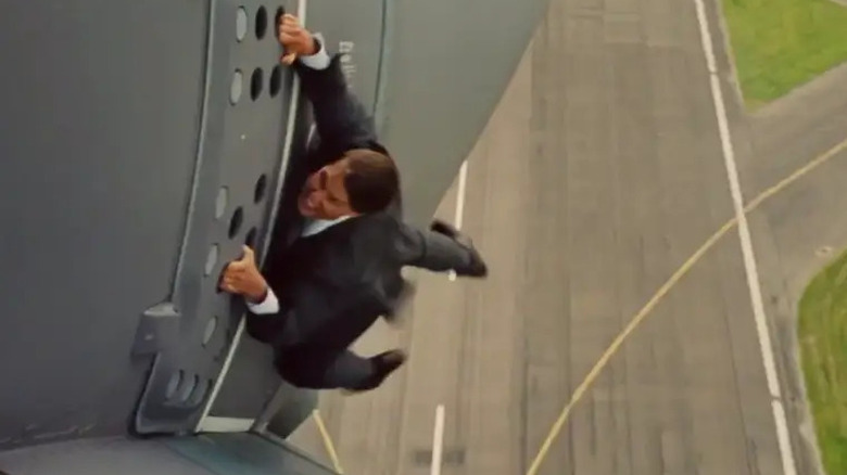 Tom Cruise as Ethan hanging from plane