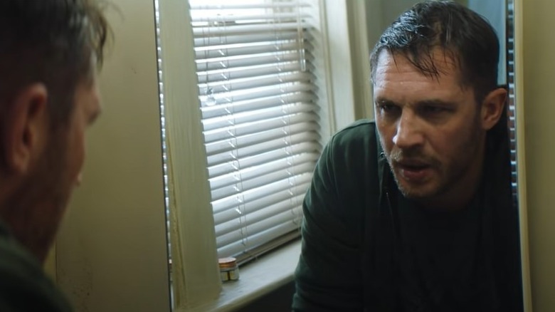 Tom Hardy looking in a mirror in Venom