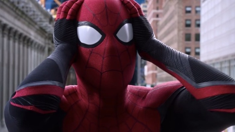 Tom Holland as Spider-Man in suit holding head
