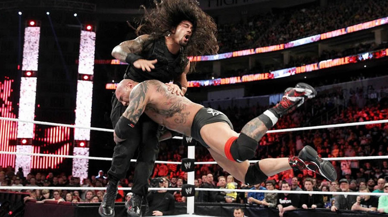 Batista spears Roman Reigns