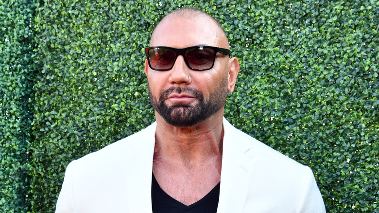 Dave Bautista in front of green wall