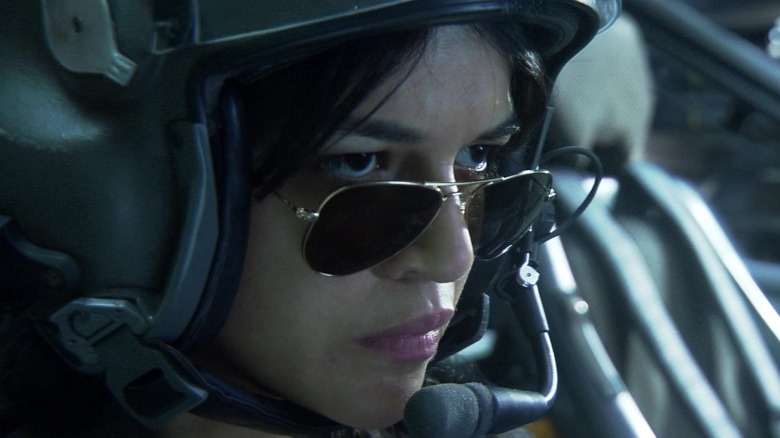 Michelle Rodriguez in sunglasses and a helicopter pilot helmet