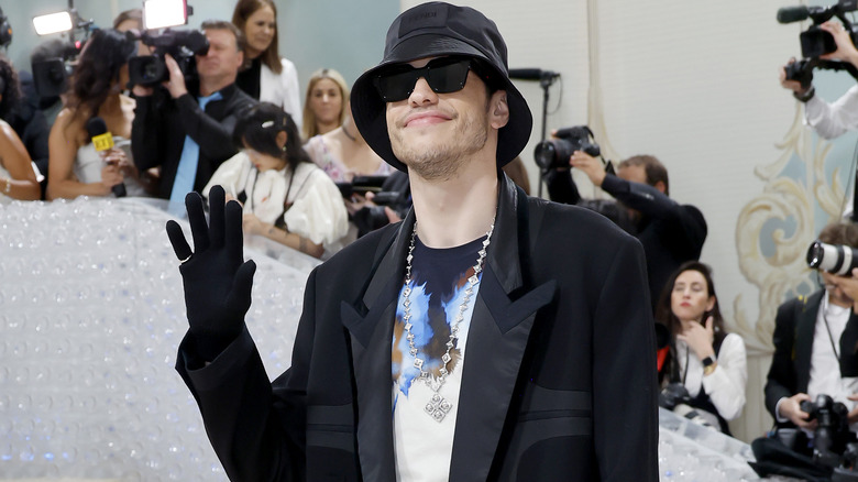 Pete Davidson waving hello at a carpet event