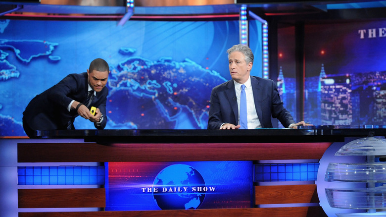 Trevor Noah measuring Jon Stewart's desk