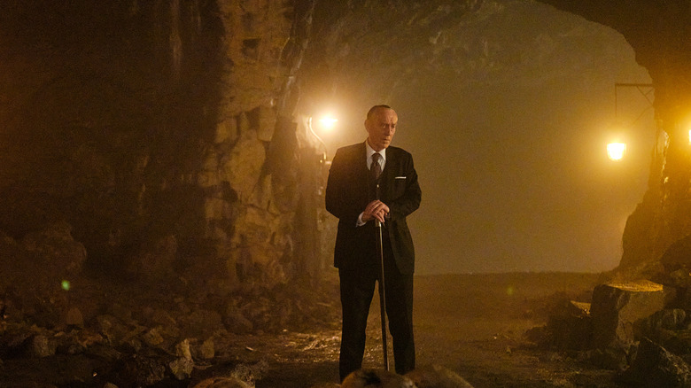 Rikard Sinding holding a cane in cave