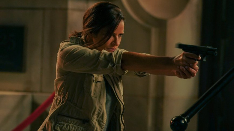 Andrea Savage holding a gun