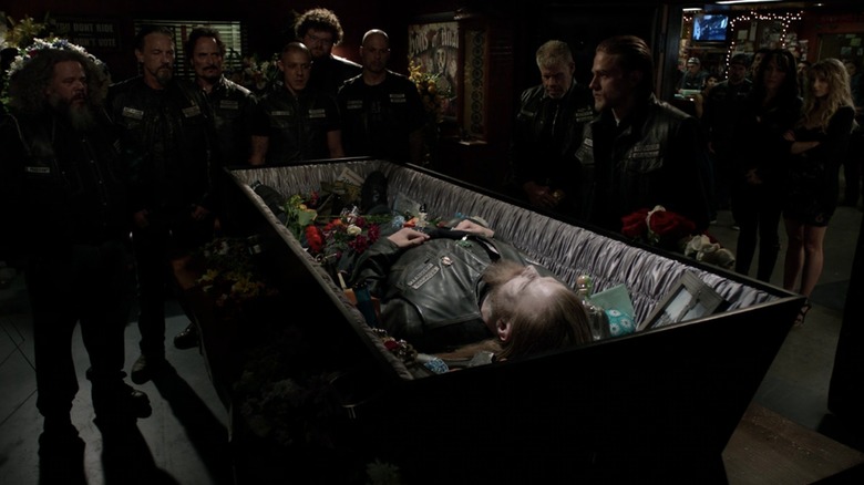 SAMCRO standing around a casket