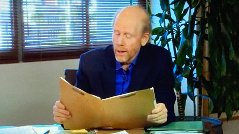 Ron Howard sits at a desk