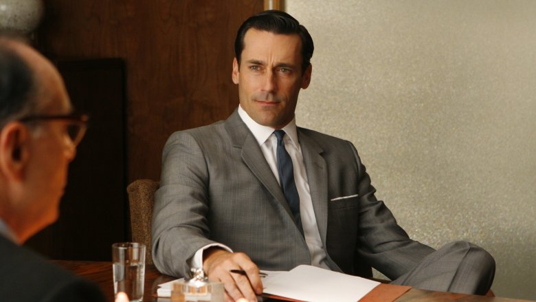 Jon Hamm as Don Draper sitting in a chair in Mad Men