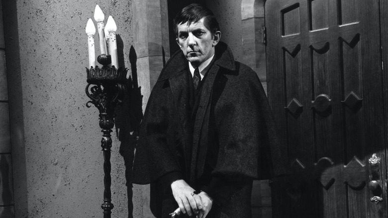 Barnabas stands in front of a door