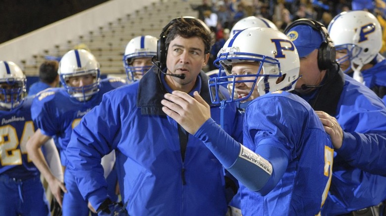 Coach talks to football player during the game