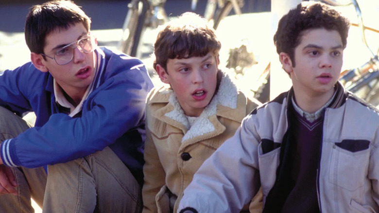 Bill, Sam, and Neil look surprised sitting on a curb in "Freaks and Geeks" (1999-2000)