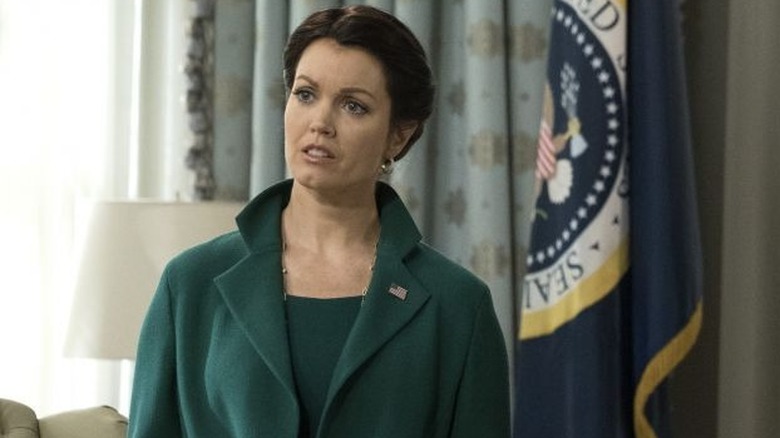 Mellie in front of presidential flag