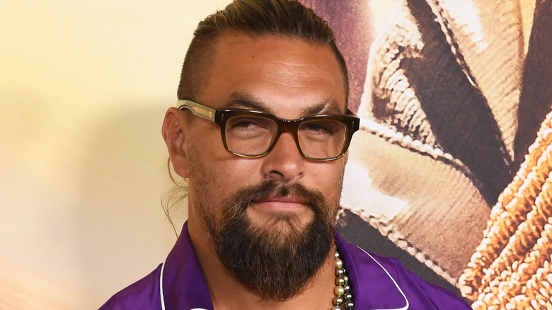 Jason Momoa stands at a red carpet event