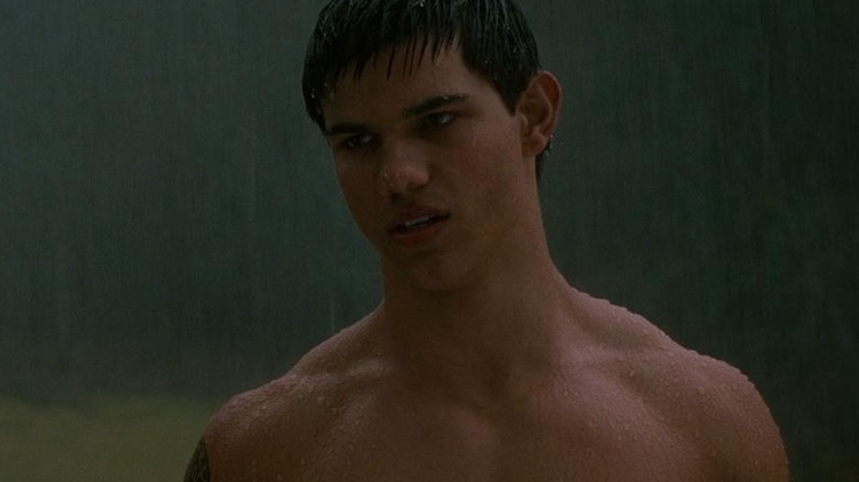 Jacob stands shirtless in the rain