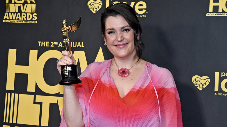 Melanie Lynskey holding a trophy and smiling