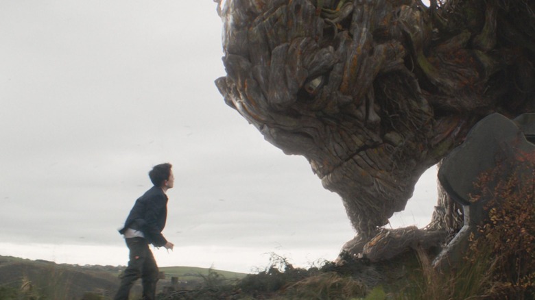 A boy faces a giant tree monster