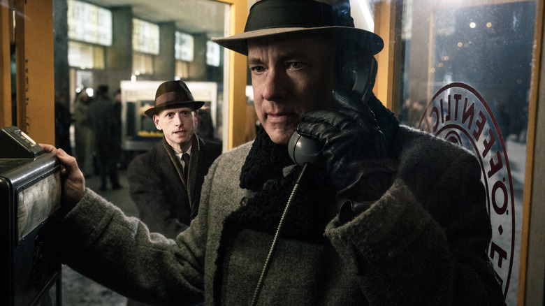 James B. Donovan holds the receiver to his ear in a phone booth